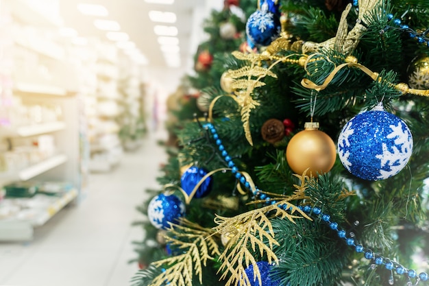 Árbol de navidad en la tienda, decorado con globos, compras y ventas de año nuevo