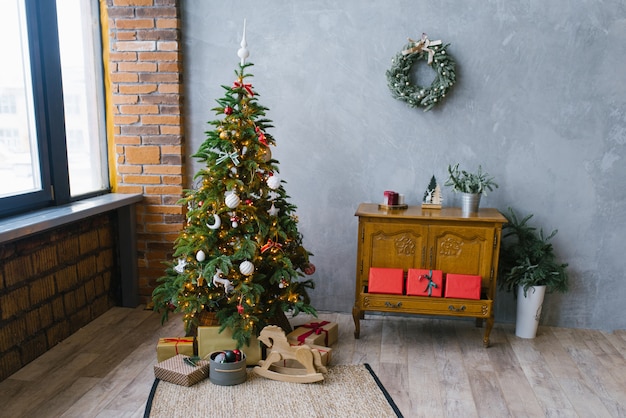 Árbol de navidad tradicional con regalos y un cofre clásico de madera