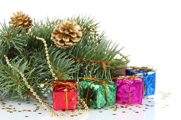 Árbol de Navidad verde con regalo y conos aislados sobre superficie blanca