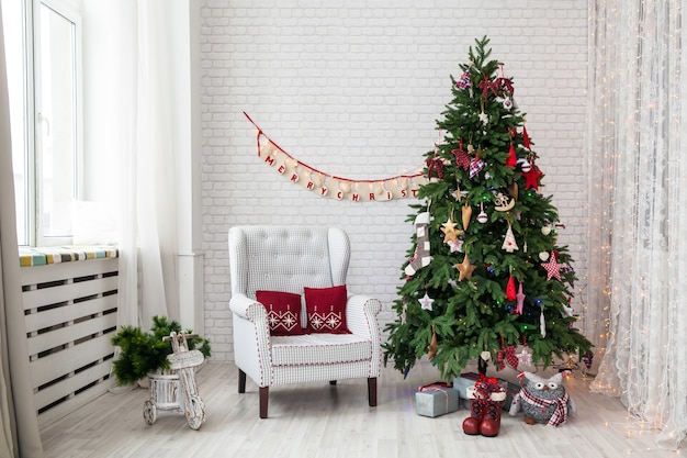 Árbol verde clásico decorado con adornos navideños.