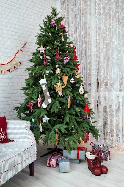 Árbol verde clásico decorado con juguetes navideños