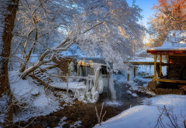 Árboles cubiertos de glaseado cerca del viejo molino Invierno helado