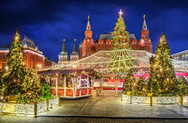 Árboles de Navidad en la Plaza Manezhnaya y el Museo Histórico con iluminación nocturna