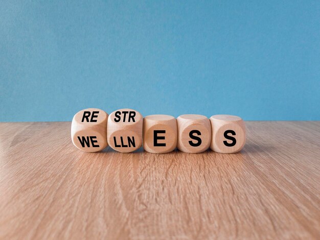 Re str ess for we lln ess símbolo Palabras conceptuales Restress y Wellness en cubos de madera