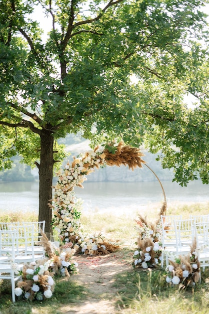 Área de ceremonia de boda con flores secas en un prado en un bosque verde