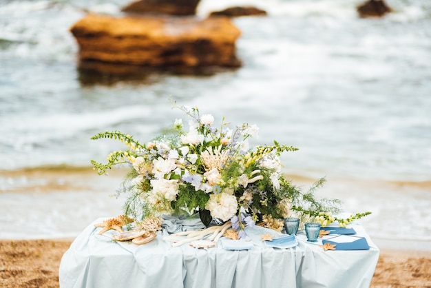 Área de ceremonia de boda en la playa de arena cerca del océano.