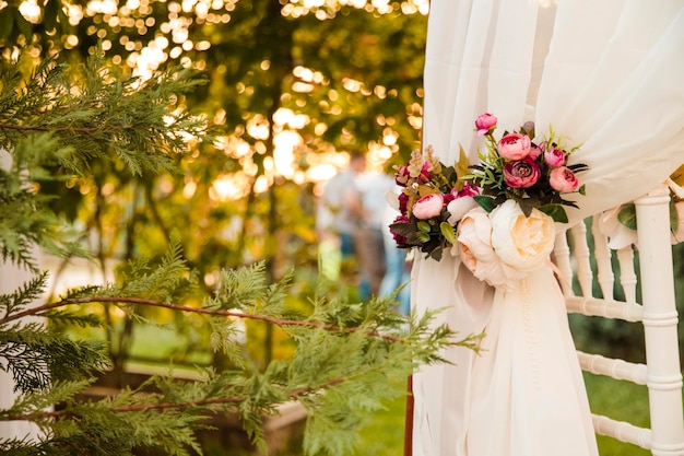 Área de ceremonia vacía Paisaje de flores y un camino de vegetación Sillas blancas Hermosa decoración floral del lugar de la boda y detalles de la ceremonia