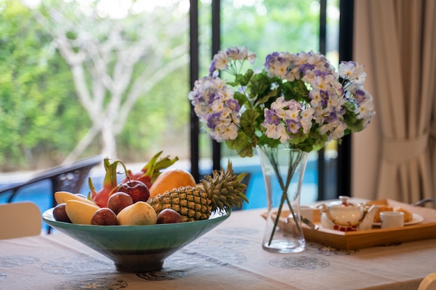 Área de comedor con vista a la piscina y canasta de frutas