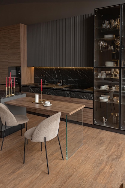 Área de cozinha em um interior chique e caro de uma casa de luxo com um design moderno preto e marrom escuro com guarnição de madeira e luz led