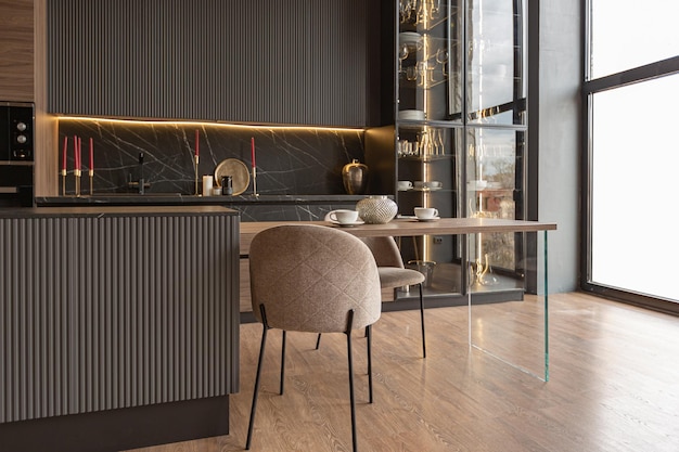 Área de cozinha em um interior chique e caro de uma casa de luxo com um design moderno preto e marrom escuro com guarnição de madeira e luz led