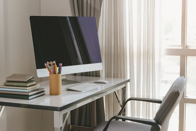 Área de trabalho do computador em branco com teclado, diário e outros acessórios na mesa branca