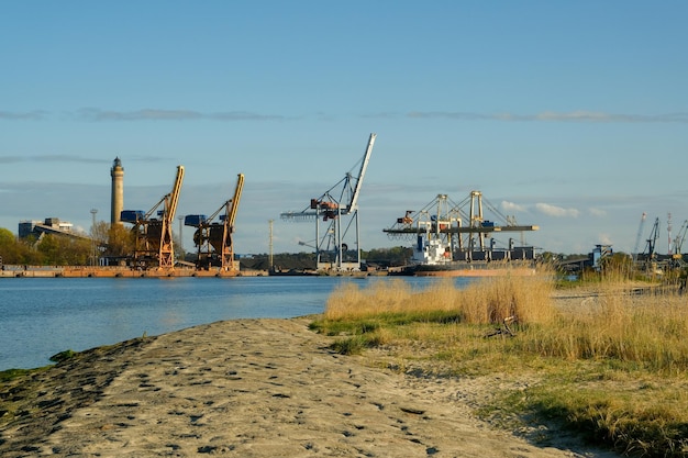 Área industrial nos guindastes grandes da costa no porto de fundo