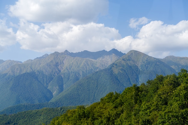 Área montanhosa cênica contra o céu azul com nuvens