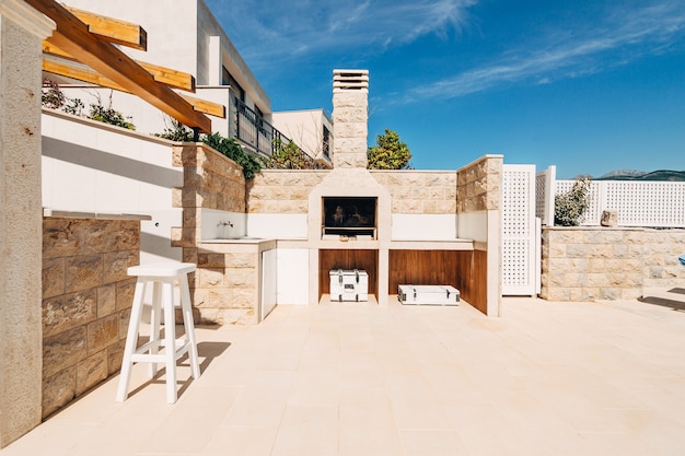 Área de parrilla en la villa junto al mar un gran patio con una parrilla de piedra y una piedra blanca abierta