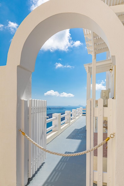 Área privativa, porta de entrada branca e vista para o céu azul. Arquitetura branca na ilha de Santorini, Grécia