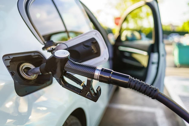 Reabasteça em um posto de gasolina com a mangueira no carro