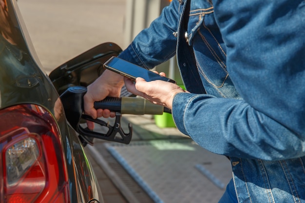 Reabastecer um carro e pagar usando o aplicativo em um smartphone