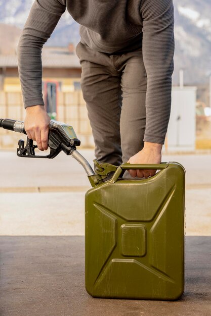 Foto reabastecimiento de botella con combustible en la gasolinera vista de cerca combustible gasolina diesel