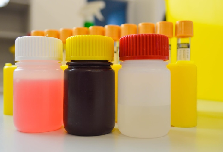 Foto reactivos para realizar pruebas de laboratorio medios líquidos en recipientes multicolores para laboratorio