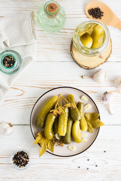 Readytoeat eingelegte Gurken auf einem Teller und Zutaten zum Kochen auf einem Holztisch Hausgemachte Snacks Ansicht von oben und vertikal