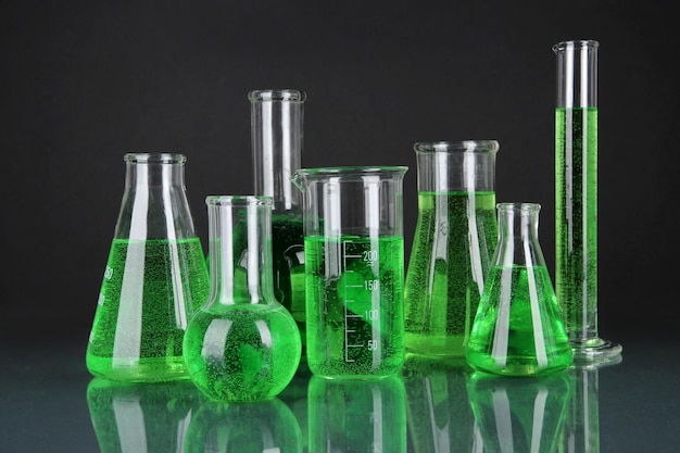 Reagenzgläser mit grüner Flüssigkeit auf dunkelgrauem Hintergrund