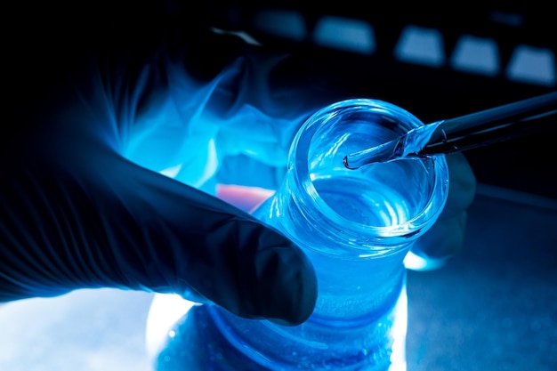 Reagenzglas aus blauem Glas, asiatische Wissenschaftlerin mit Reagenzgläsern, die in klinischen Labors forschen