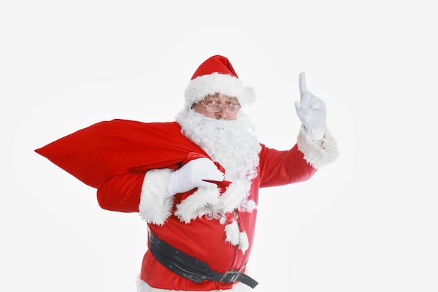 Real santa claus llevando una bolsa grande llena de regalos aislado sobre fondo blanco.