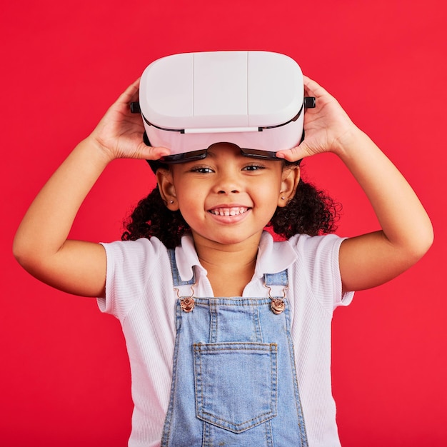 Foto realidade virtual de retrato ou fone de ouvido para jogos de esports 3d metaversos para crianças ou jogos cibernéticos futuristas em fundo vermelho sorria criança feliz ou brincalhona e tecnologia vr gamer para diversão de fantasia digital