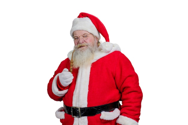 Realistischer Weihnachtsmann, der seine Pfeife raucht. Studioaufnahme des bärtigen Weihnachtsmannes mit Pfeife auf weißem Hintergrund.