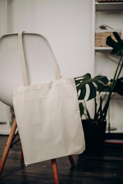Realistisches Mockup der Tasche, die auf dem Stuhl hängt Mockup des Blank-Einkaufsbeutels