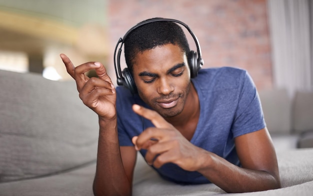 Realmente sentindo a música Foto recortada de um jovem bonito relaxando em casa com algumas músicas