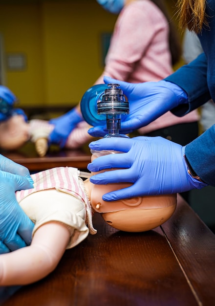 Reanimationskurse. Erste-Hilfe-Kurs am Baby-Dummy. Verwendung einer Sauerstoffmaske auf einer medizinischen Puppe.