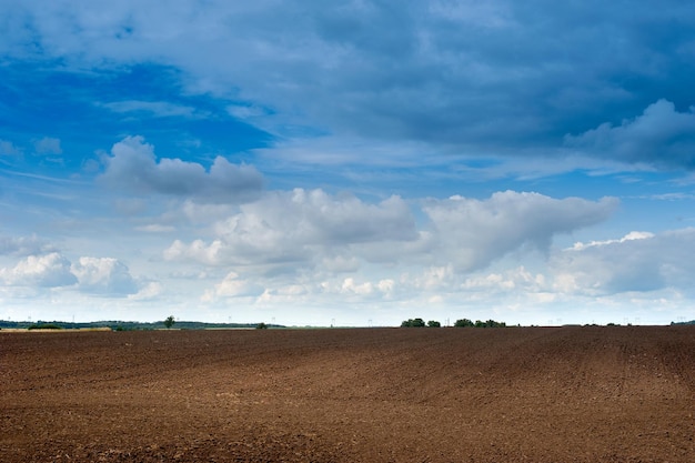 Áreas de campos aráveis preparação da paisagem para semeadura para a temporada Agricultura agrária áreas aradas e lindo céu azul com nuvens