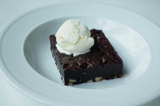 Rebanada de brownie y helado en la placa en la mesa