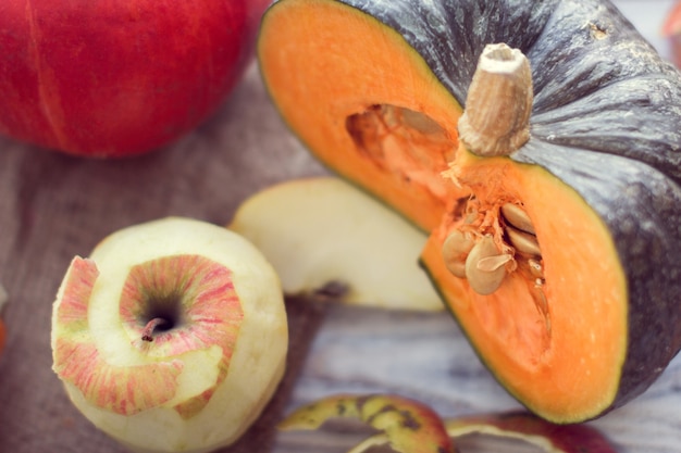 Rebanada de calabaza verde y manzana pelada sobre un fondo de madera