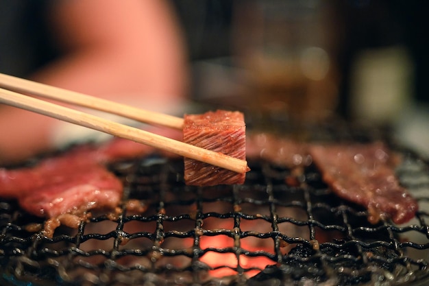 Rebanada de carne cruda asada a la parrilla en llamas