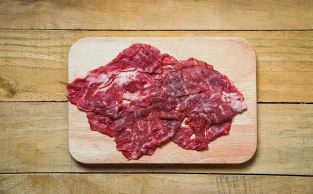 Rebanada de carne de res en una tabla de cortar de madera para alimentos japoneses o Shabu shabu cocidos o Sukiyaki.