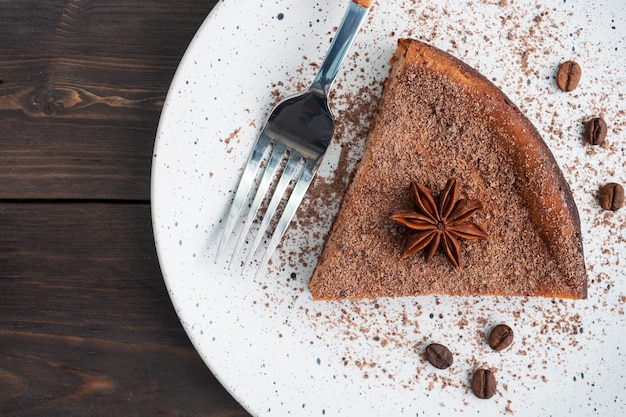 Rebanada de cazuela de cuajada de chocolate en un plato, una porción de pastel con chocolate y café. Mesa rústica de madera oscura. espacio de copia de vista superior