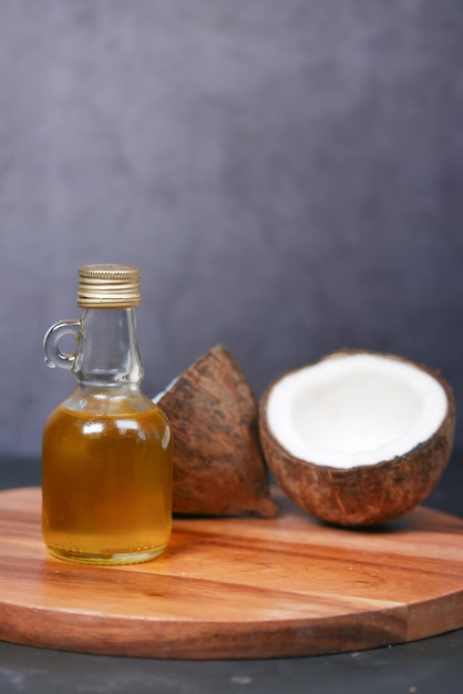 Rebanada de coco fresco y una botella de aceite sobre una mesa