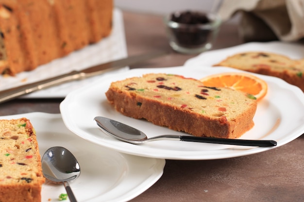 Rebanada de delicioso pudín de pastel de frutas inglés casero con frutas secas, pasas, pasas y almendras picadas. Servido durante la fiesta de Navidad o Nochevieja.