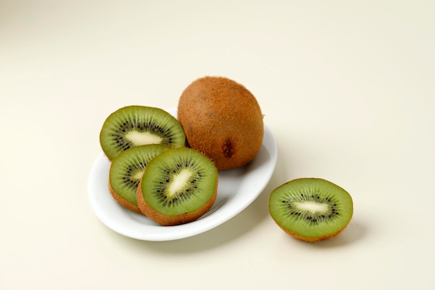 Rebanada de kiwi sobre fondo crema plato blanco