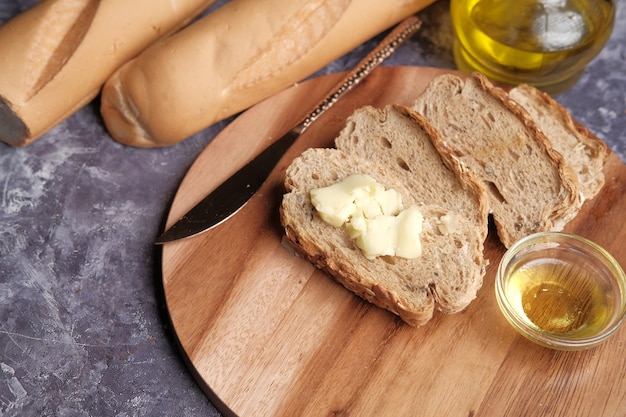 Rebanada de mantequilla y pan integral sobre una tabla de cortar