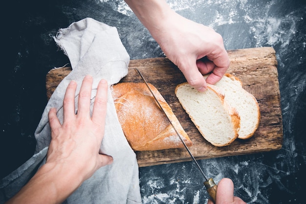 Rebanada de pan casero fresco y cuchillo sobre mesa rústica