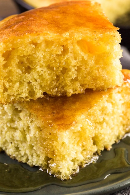 Rebanada de pan de maíz dulce con miel en el plato.