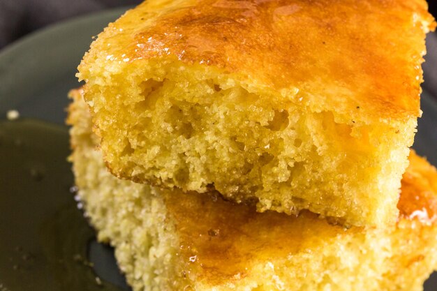 Rebanada de pan de maíz dulce con miel en el plato.