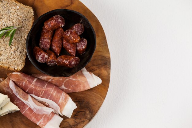 Rebanada de pan, queso y carne sobre tabla de madera