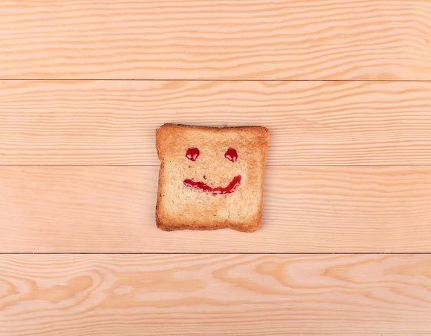 Rebanada de pan con una sonrisa en madera