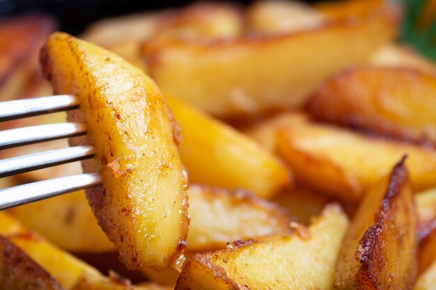 Rebanada de papas al horno en primer plano de un tenedor