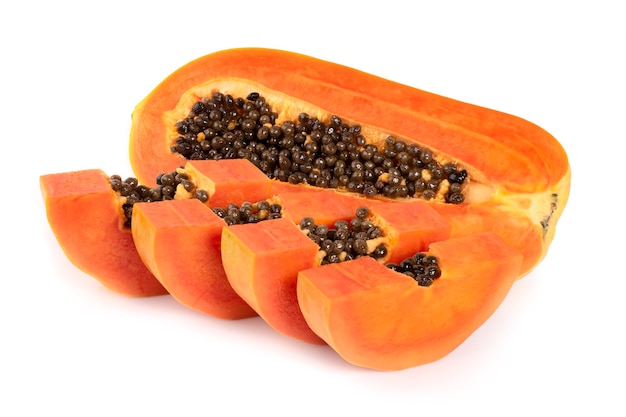 Rebanada de papaya madura con hojas aisladas sobre fondo blanco.