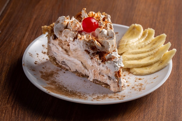 Rebanada de pastel Banoffee con relleno de plátano y salsa de caramelo Pastel inglés tradicional